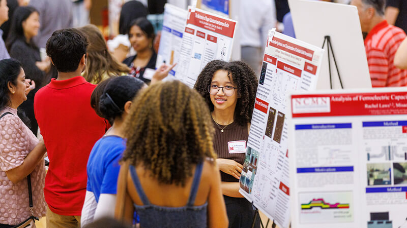 Students present at poster session of UNL research fair.