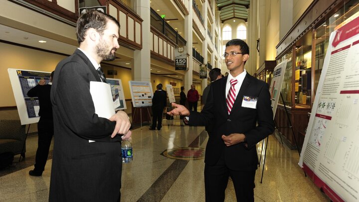 Wilson presents his poster to a judge